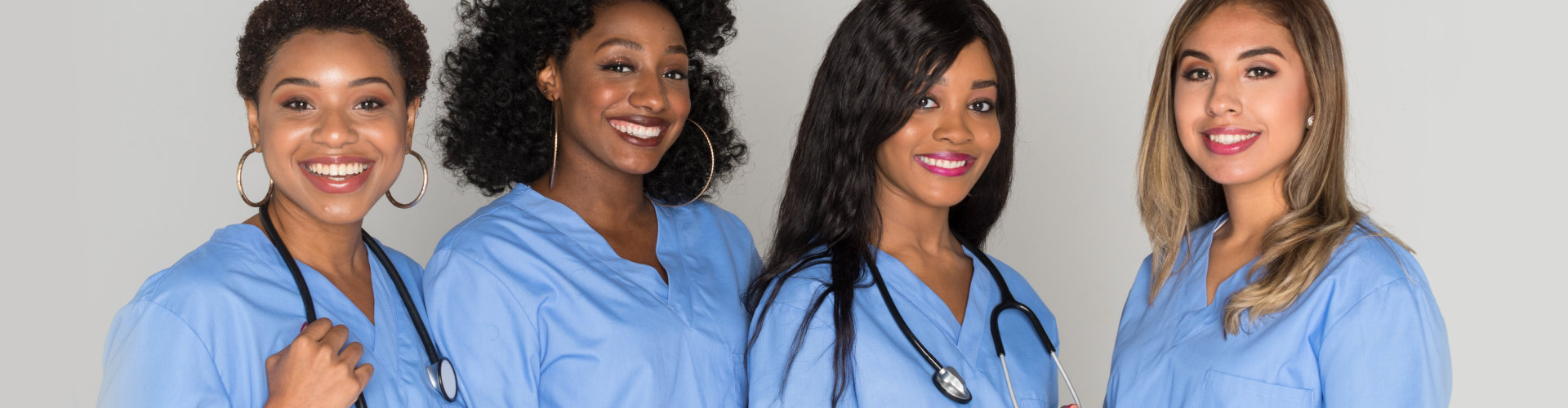 four female nurses smiling on camera